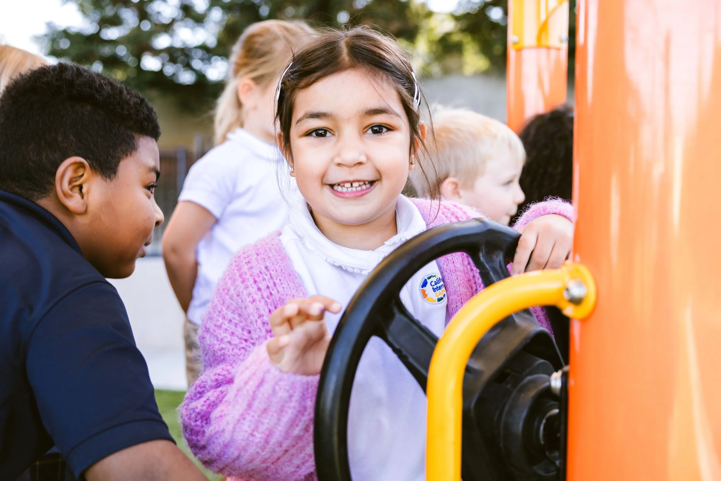 Students playing and learning together on colorful playground equipment