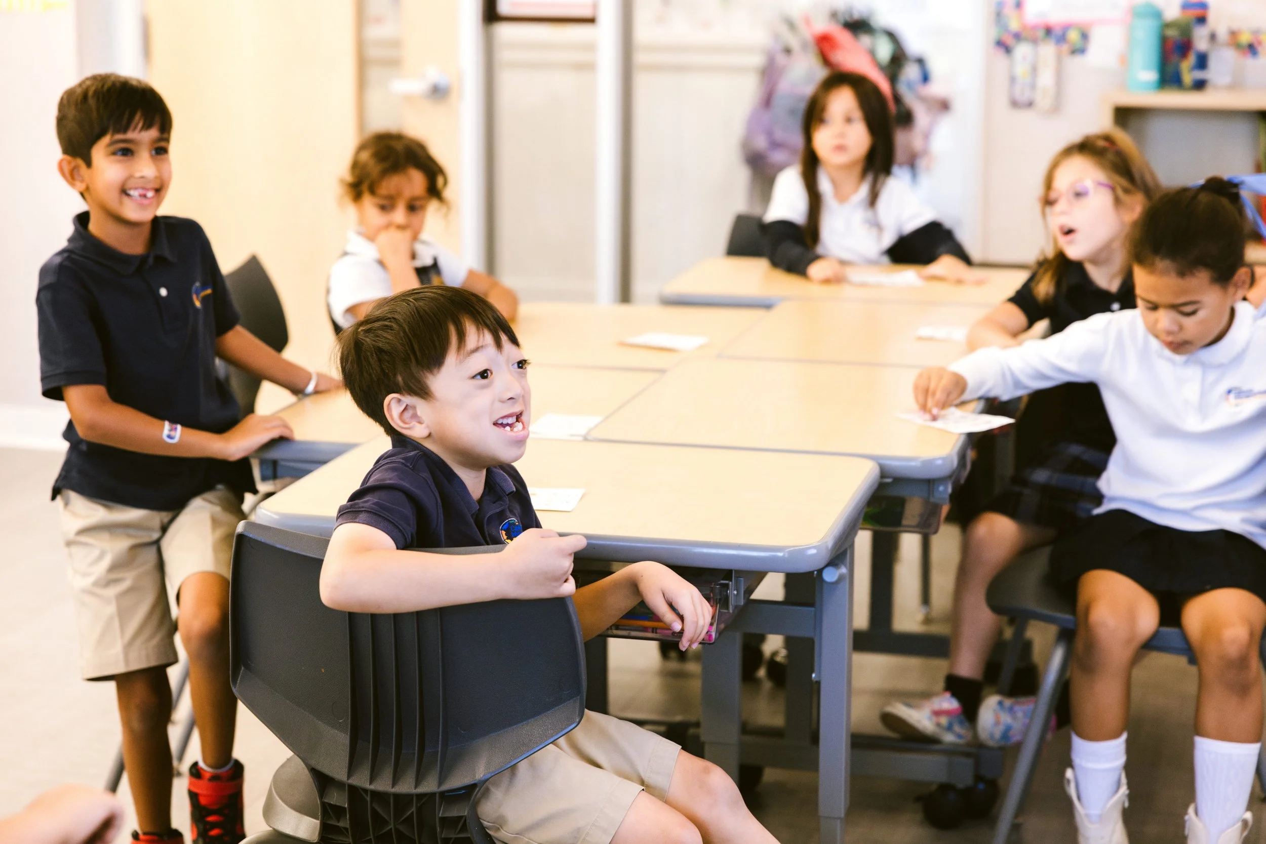 Young students engaged in collaborative classroom activity at learning tables