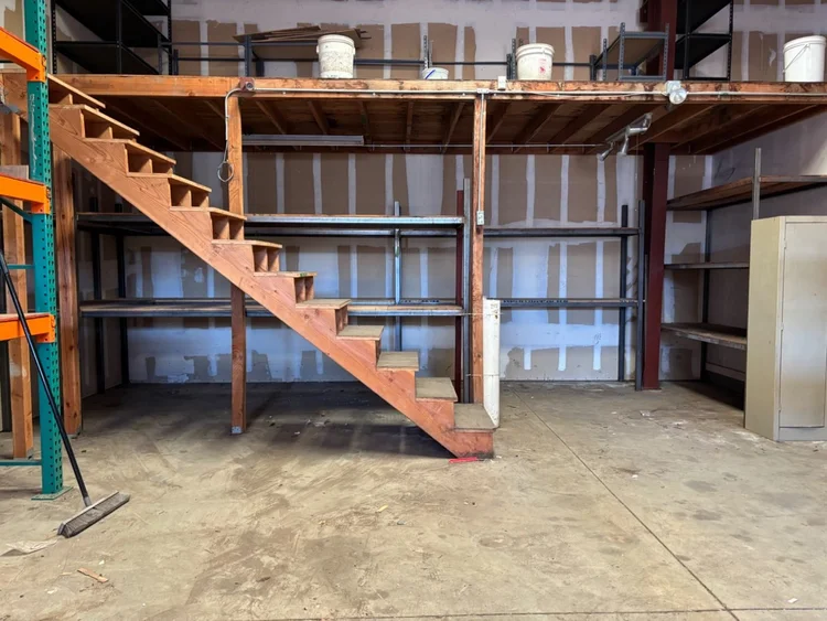 Warehouse stair area with cleared floor and shelves after removal