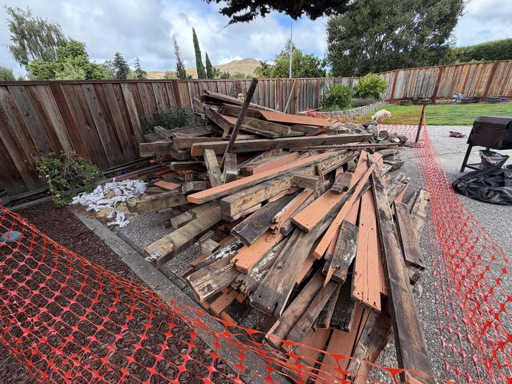 Large pile of dismantled lumber before Junk Boys pickup
