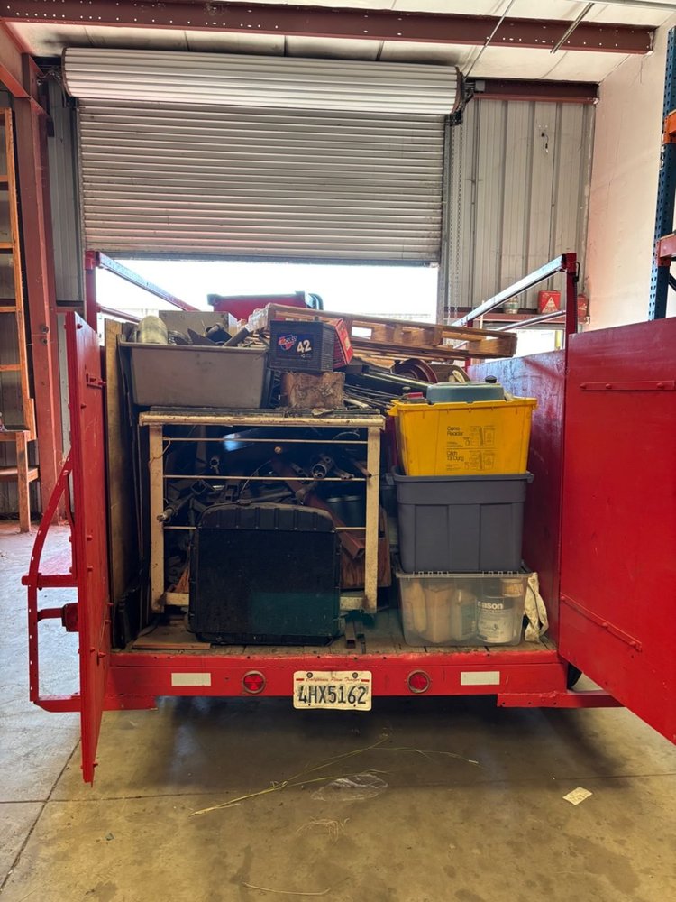 Red Junk Boys trailer loaded with items at the warehouse