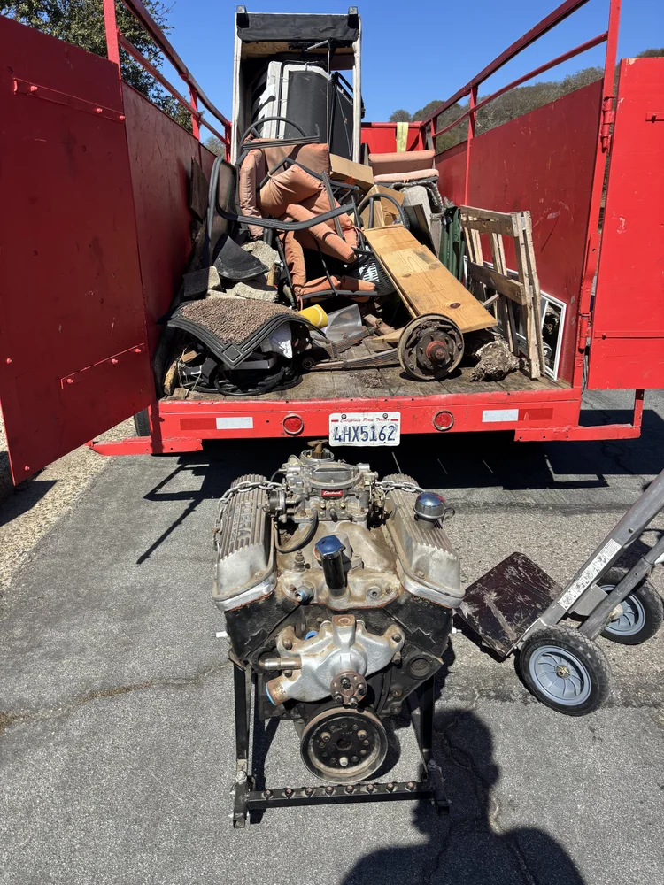 Engine on a dolly beside the Junk Boys trailer with a mixed load