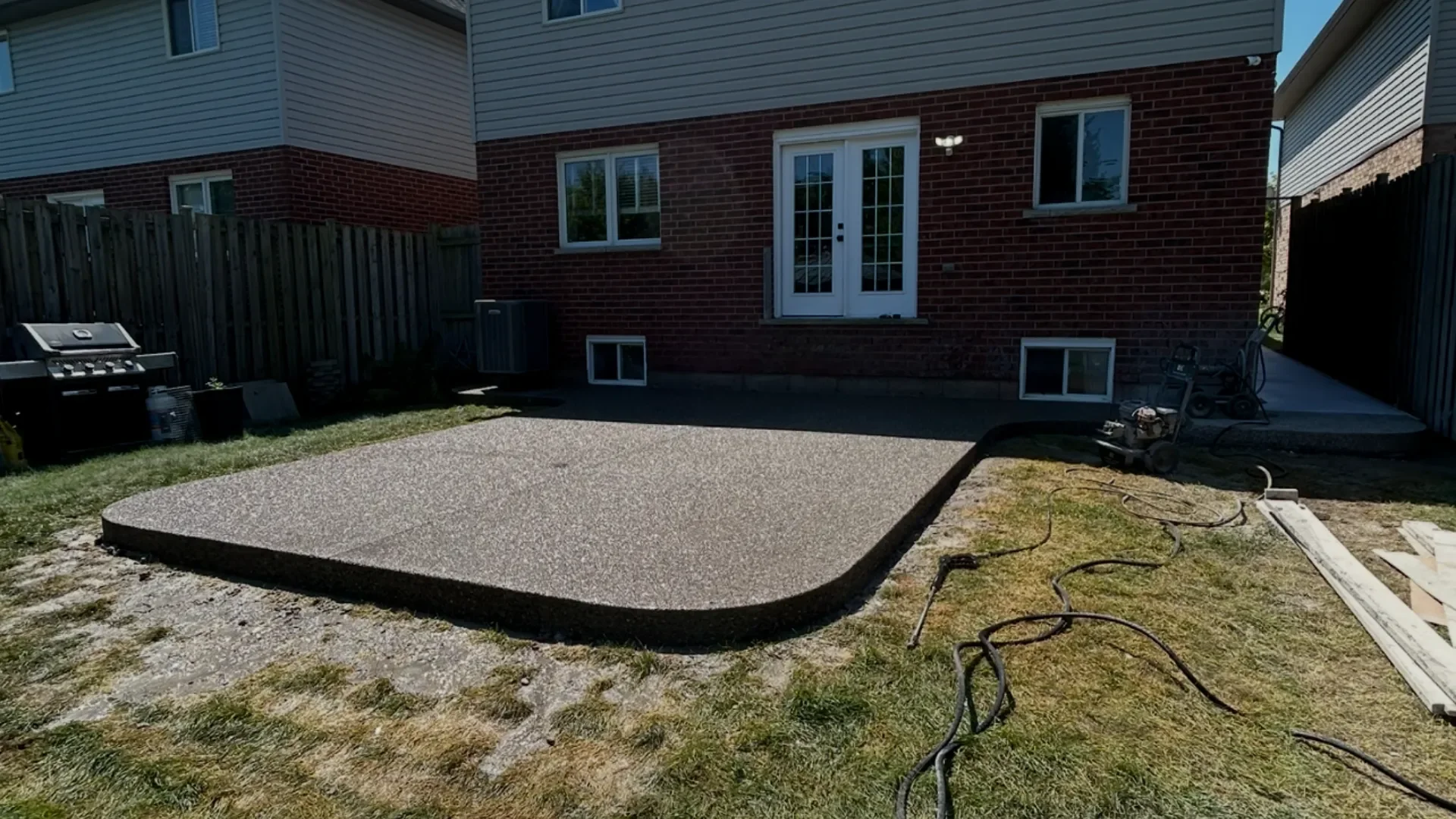 Exposed aggregate concrete patio with rounded corner in Grimsby