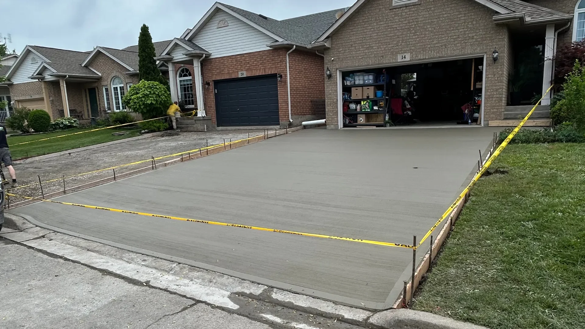 Fresh broom-finish concrete driveway with forms and caution tape in St. Catharines