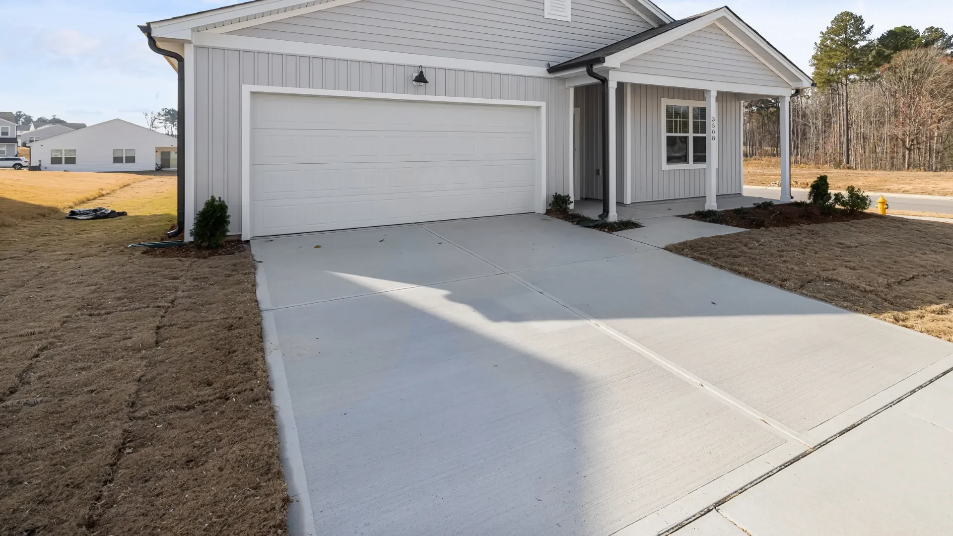 new concrete driveway leading to a two-car garage