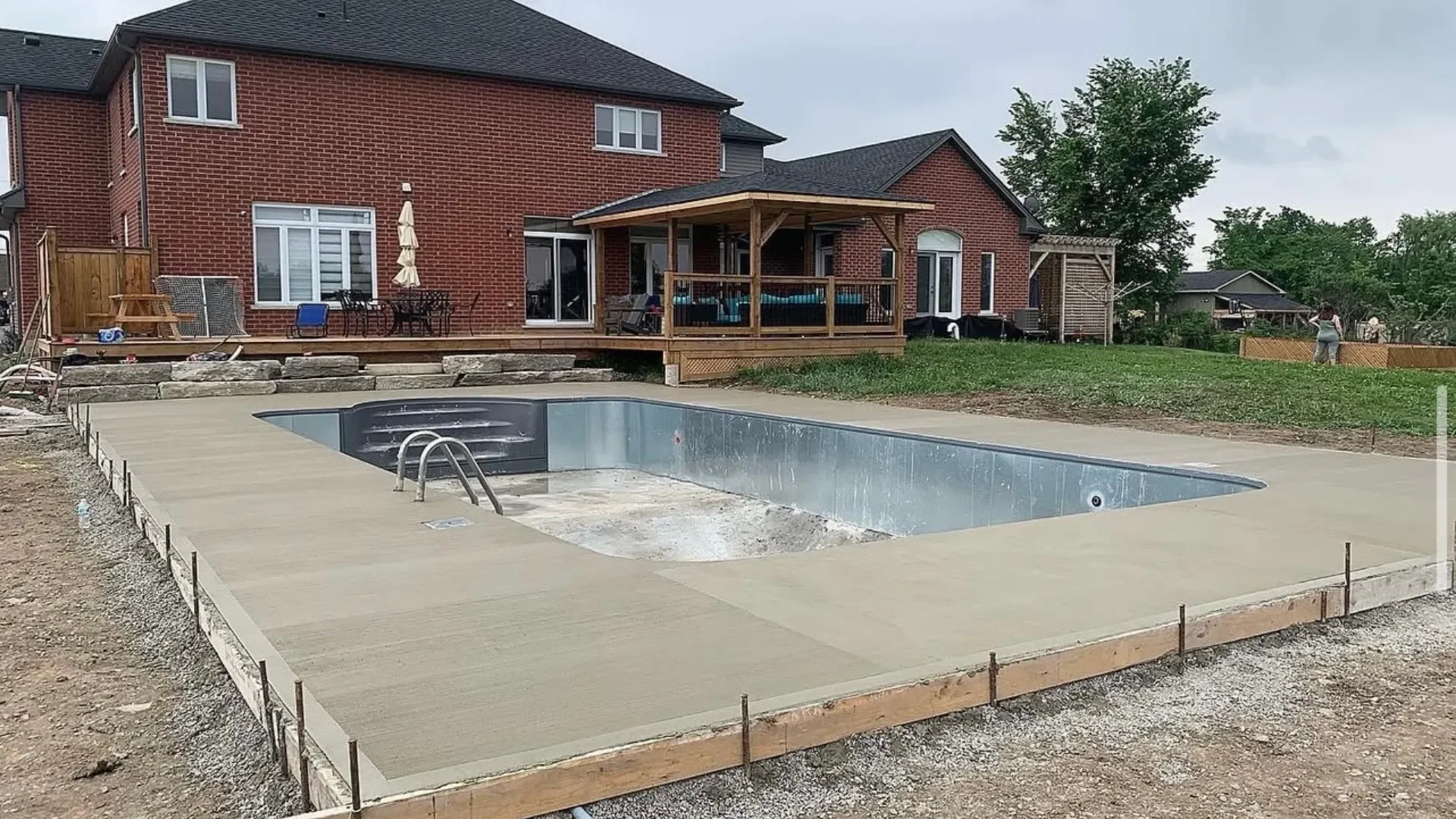 Fresh concrete pool deck with forms still in place around a Fort Erie pool