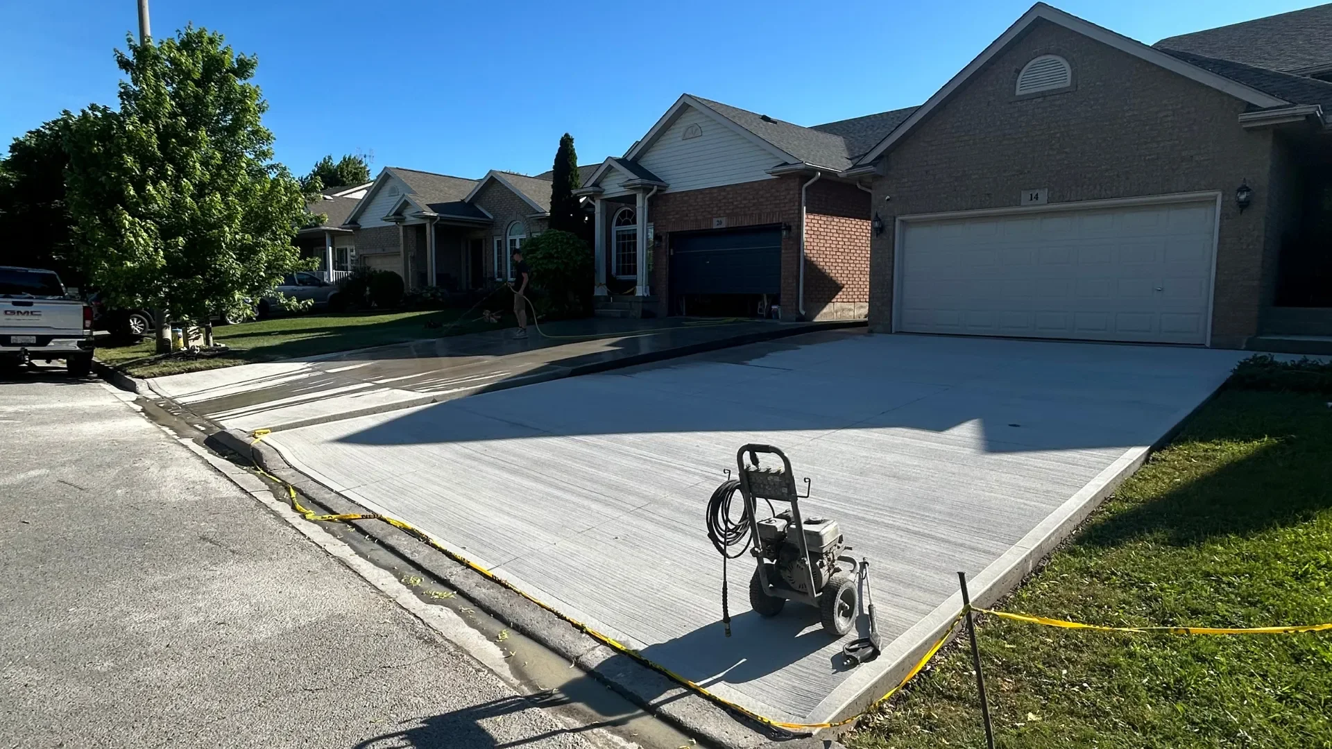 Newly finished broom-finish concrete driveway on a sunny suburban street in St. Catharines
