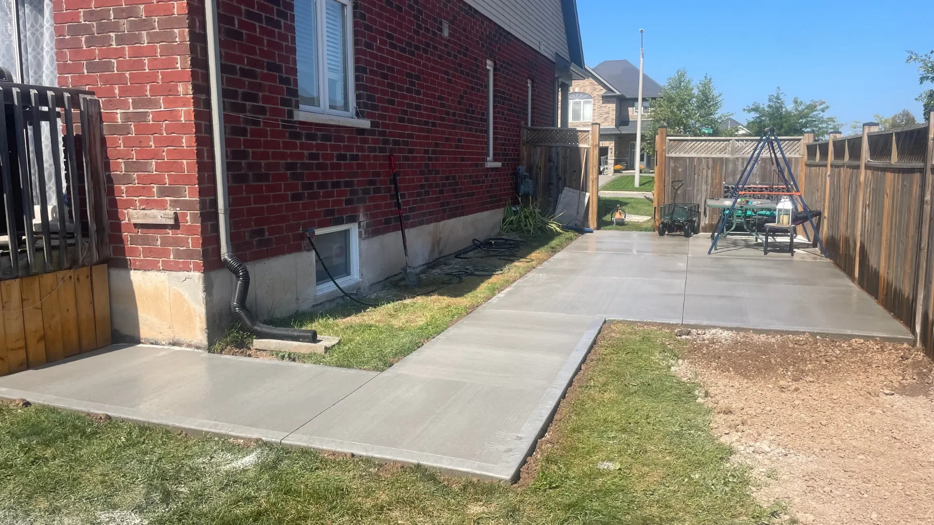 L-shaped concrete patio and walkway from a wooden deck in Grimsby