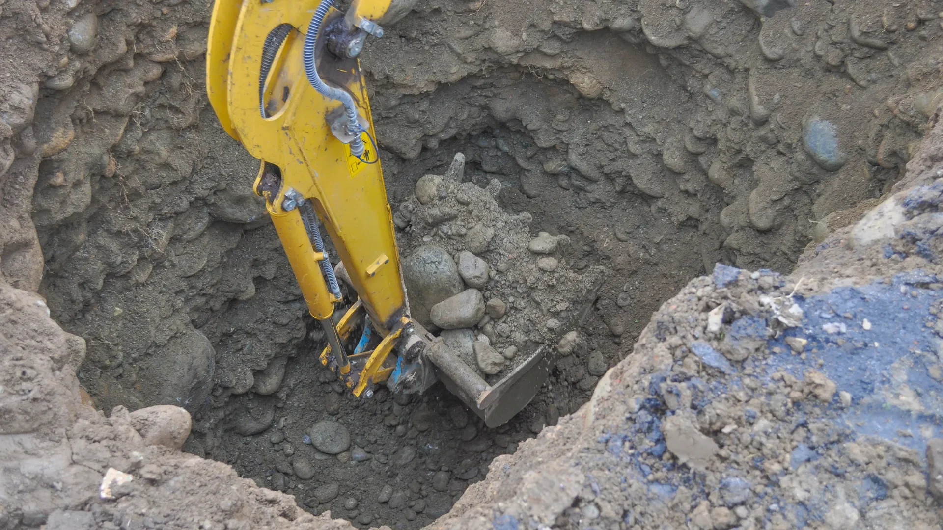 Brick and concrete rubble pile with excavator during site clearing
