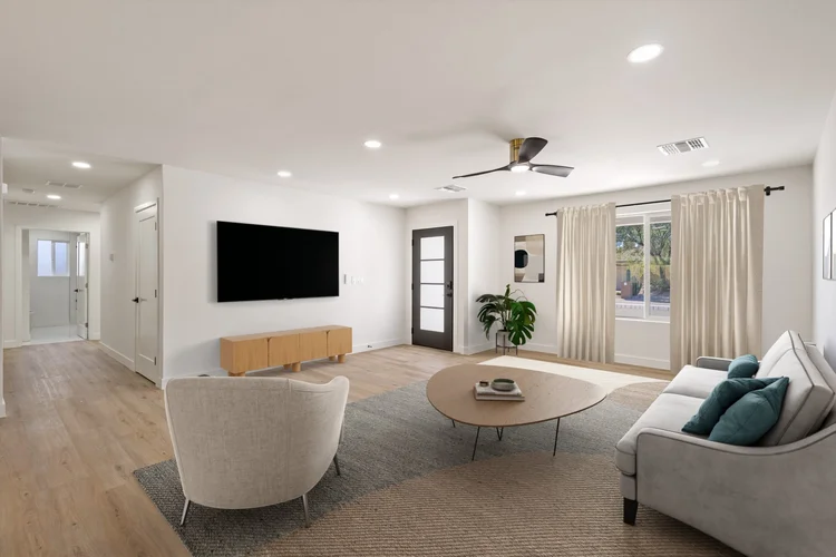 Bright staged living room with a round coffee table and sectional