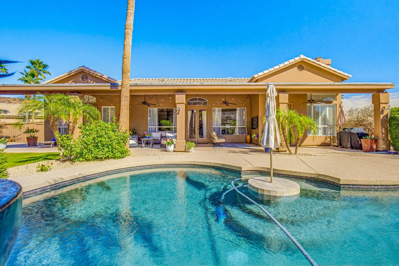 Backyard pool and covered patio of a Chandler home, photographed by Valley View Photo