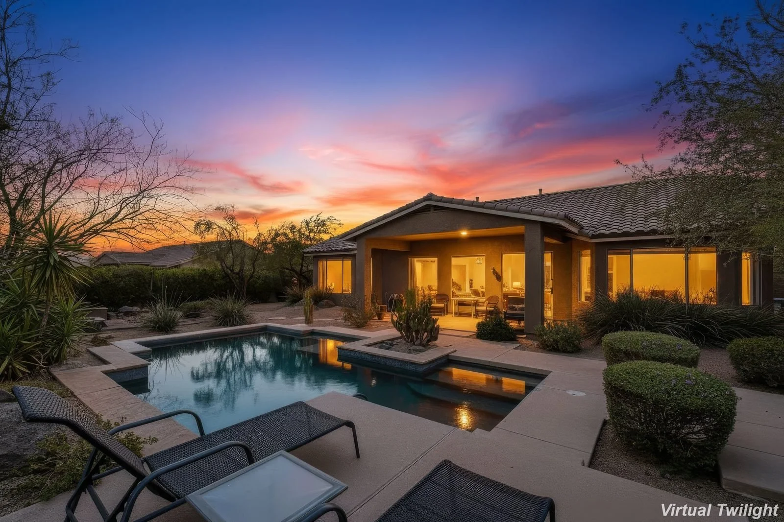 Twilight photo of a Peoria home with backyard pool and water feature, lit interior visible through windows