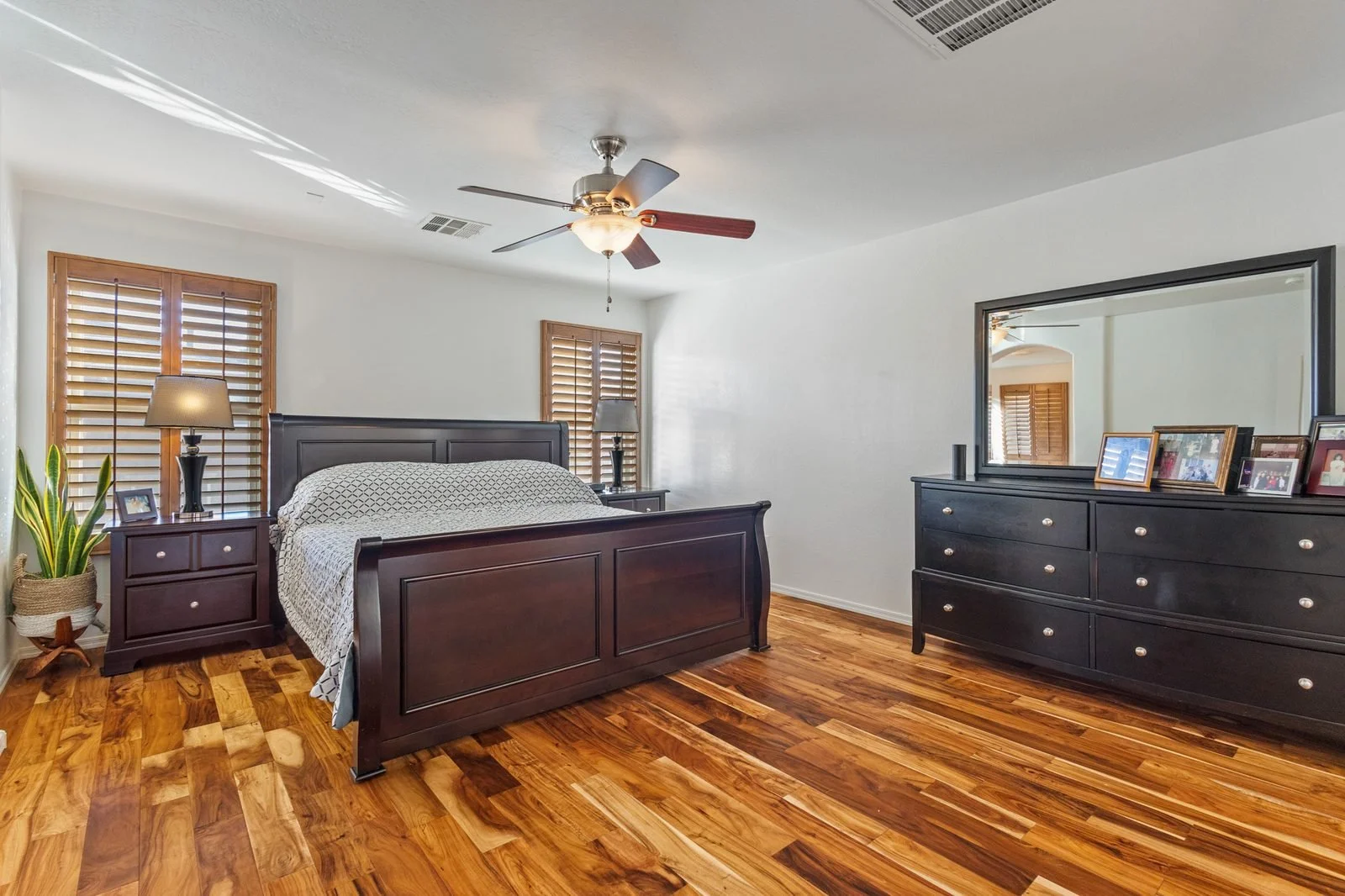 Primary bedroom with dark wood furniture in a Mesa home