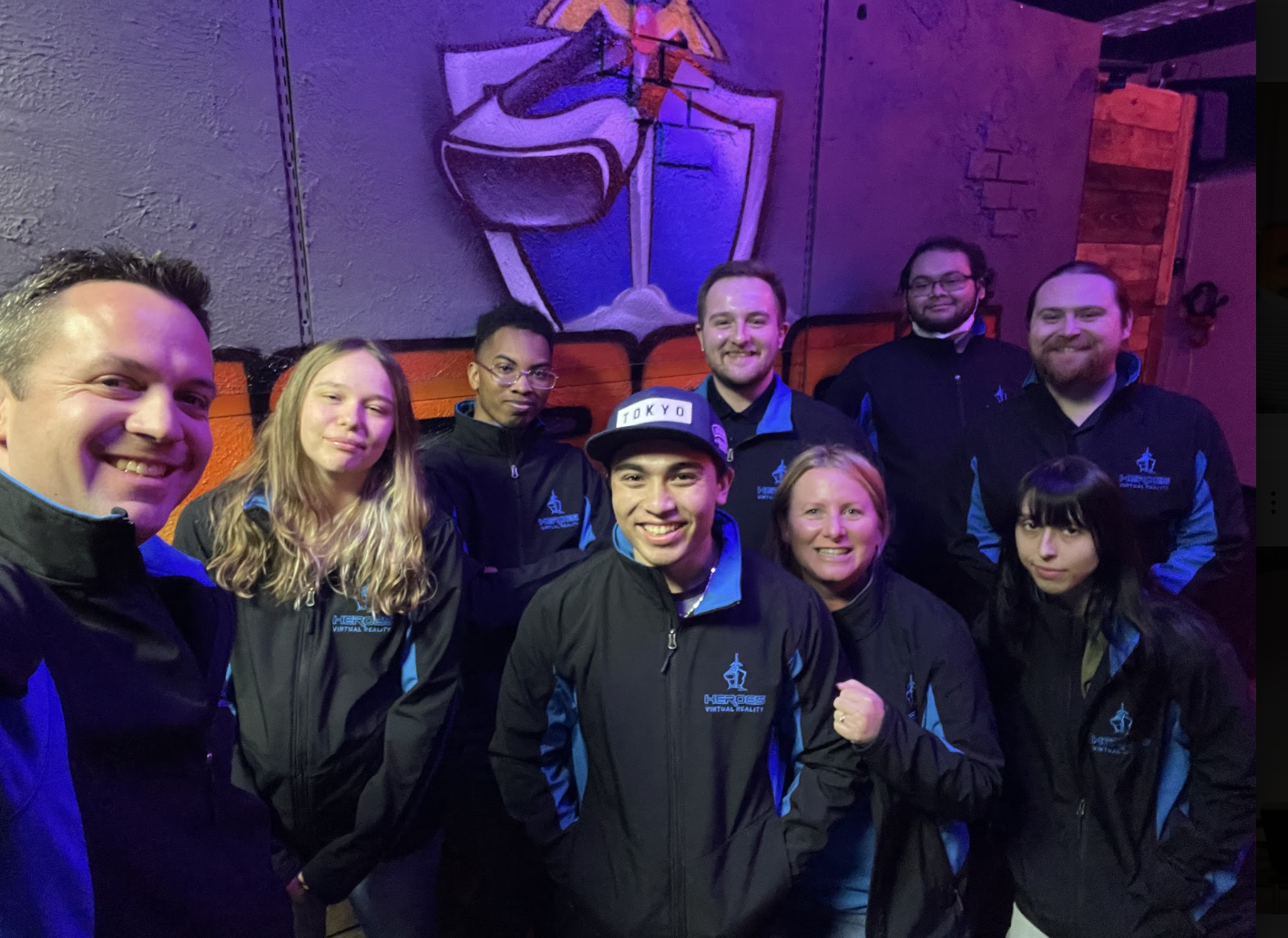 HEROES VR Adventures staff wearing matching branded jackets and posing for a group selfie.