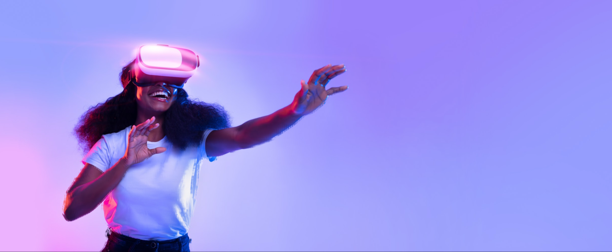 Smiling woman wearing a glowing VR headset and reaching forward against a purple background.