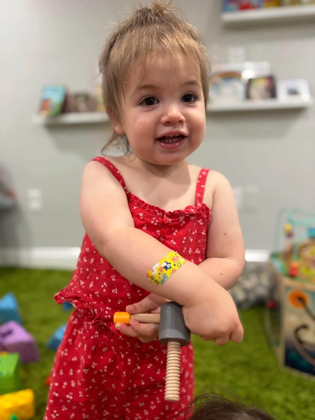 A toddler exploring a colorful toy at Gardens Day Care