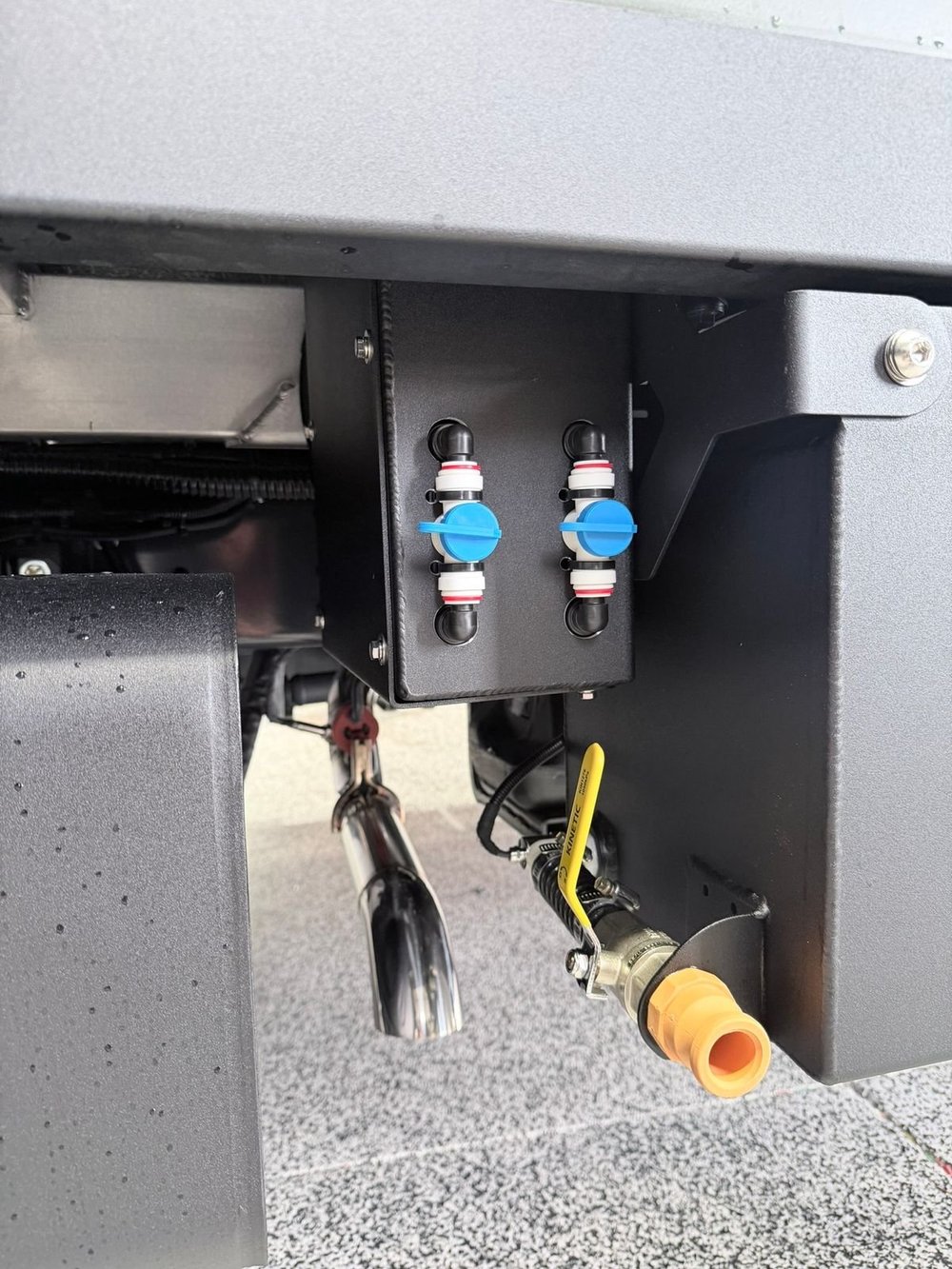 Twin self-draining quick-connect water valves mounted under the habitat