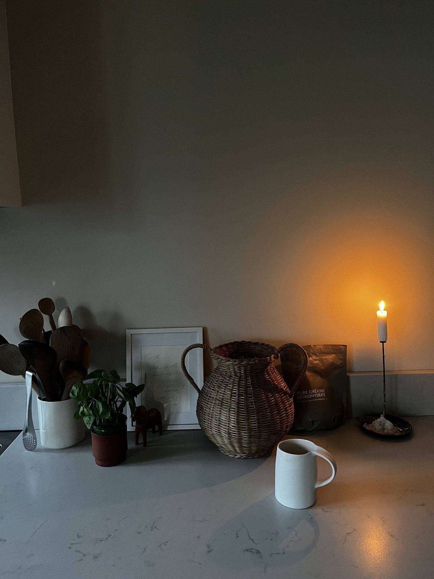 A mug on the kitchen counter by candlelight