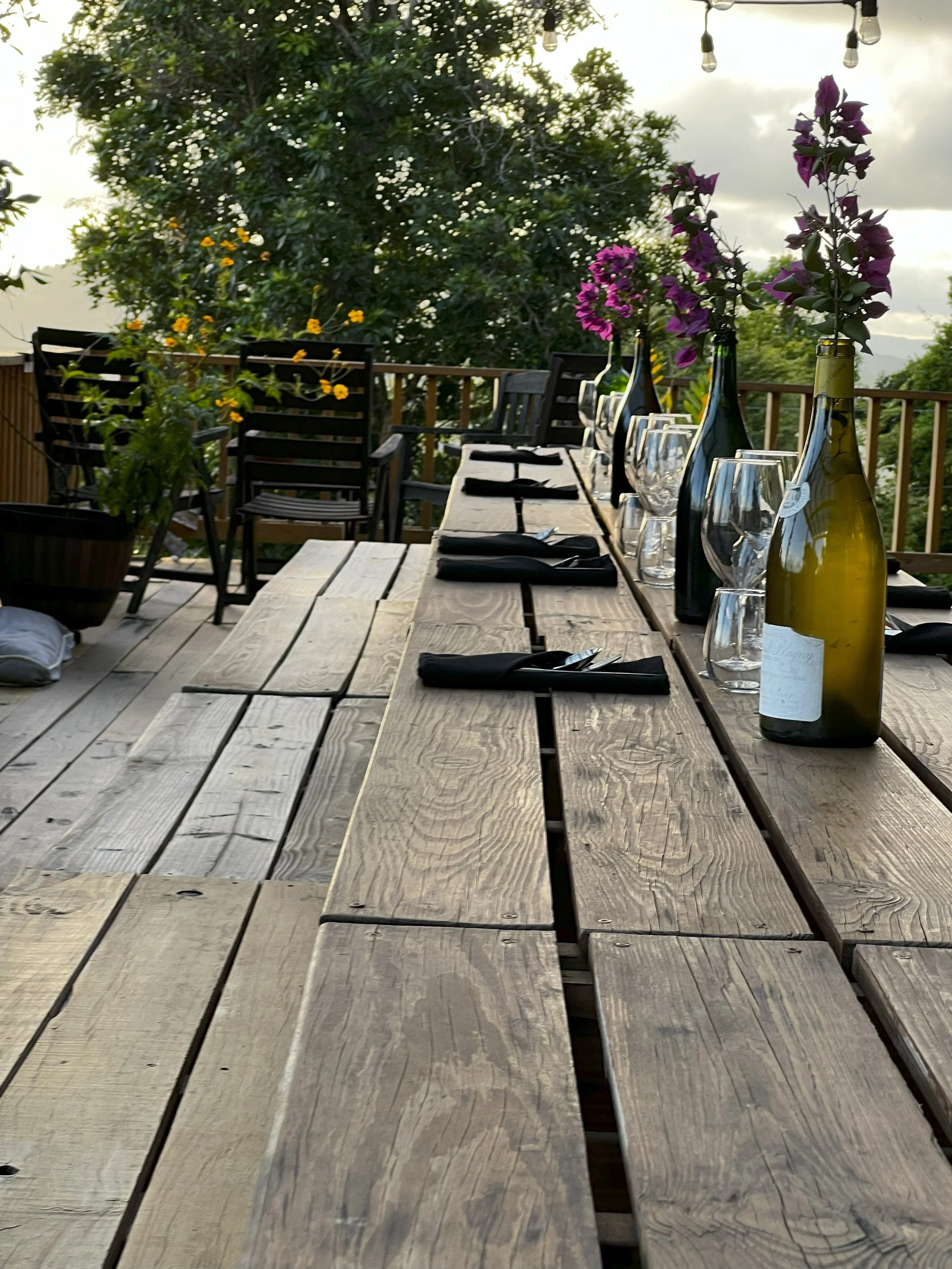 Life event table setting with wine bottles and glasses on a rustic wooden table