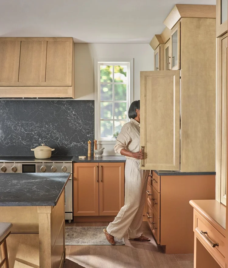 Fieldstone kitchen cabinetry pairing natural wood with terracotta-colored cabinets and dark stone surfaces