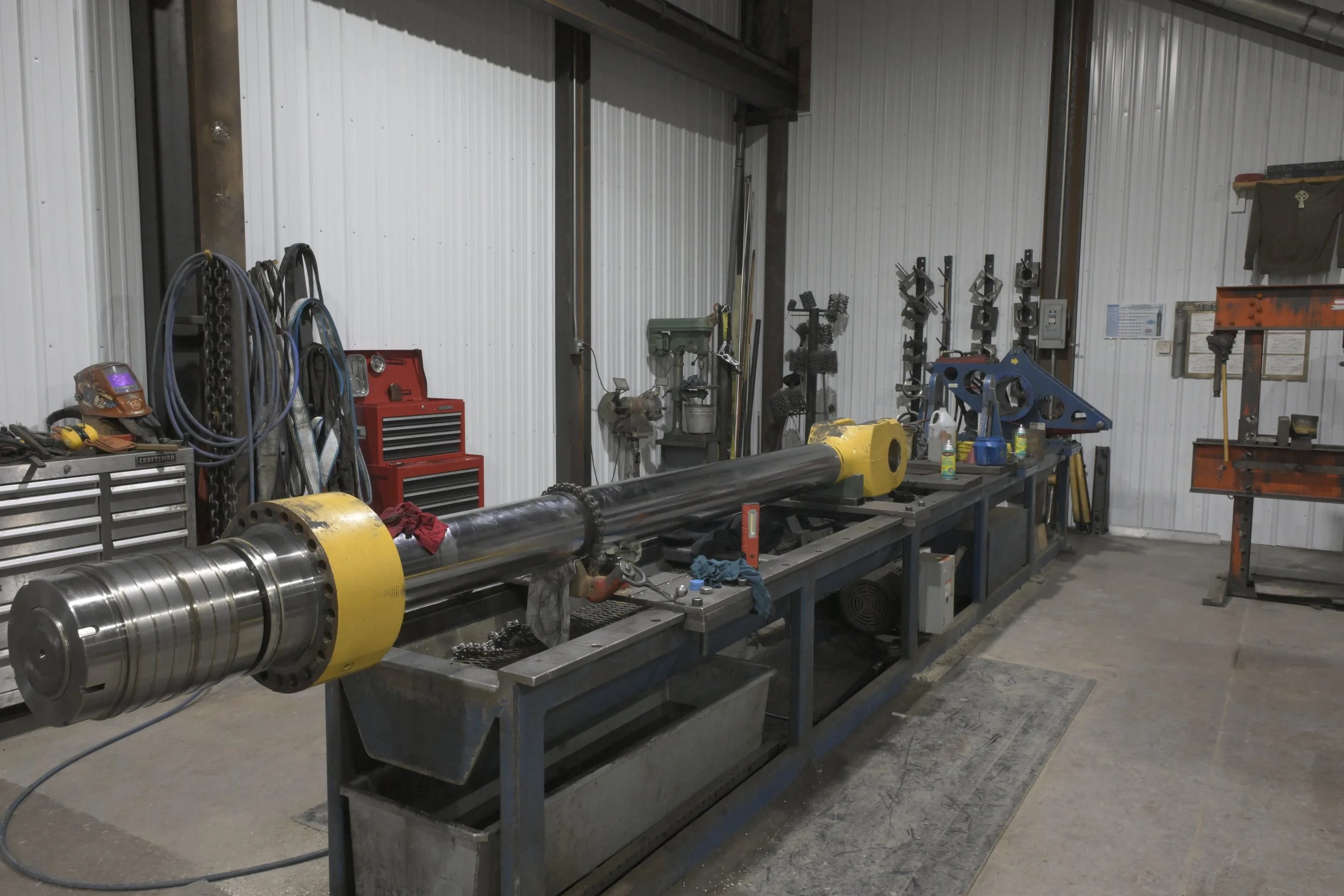 Welder performing field repairs on heavy equipment
