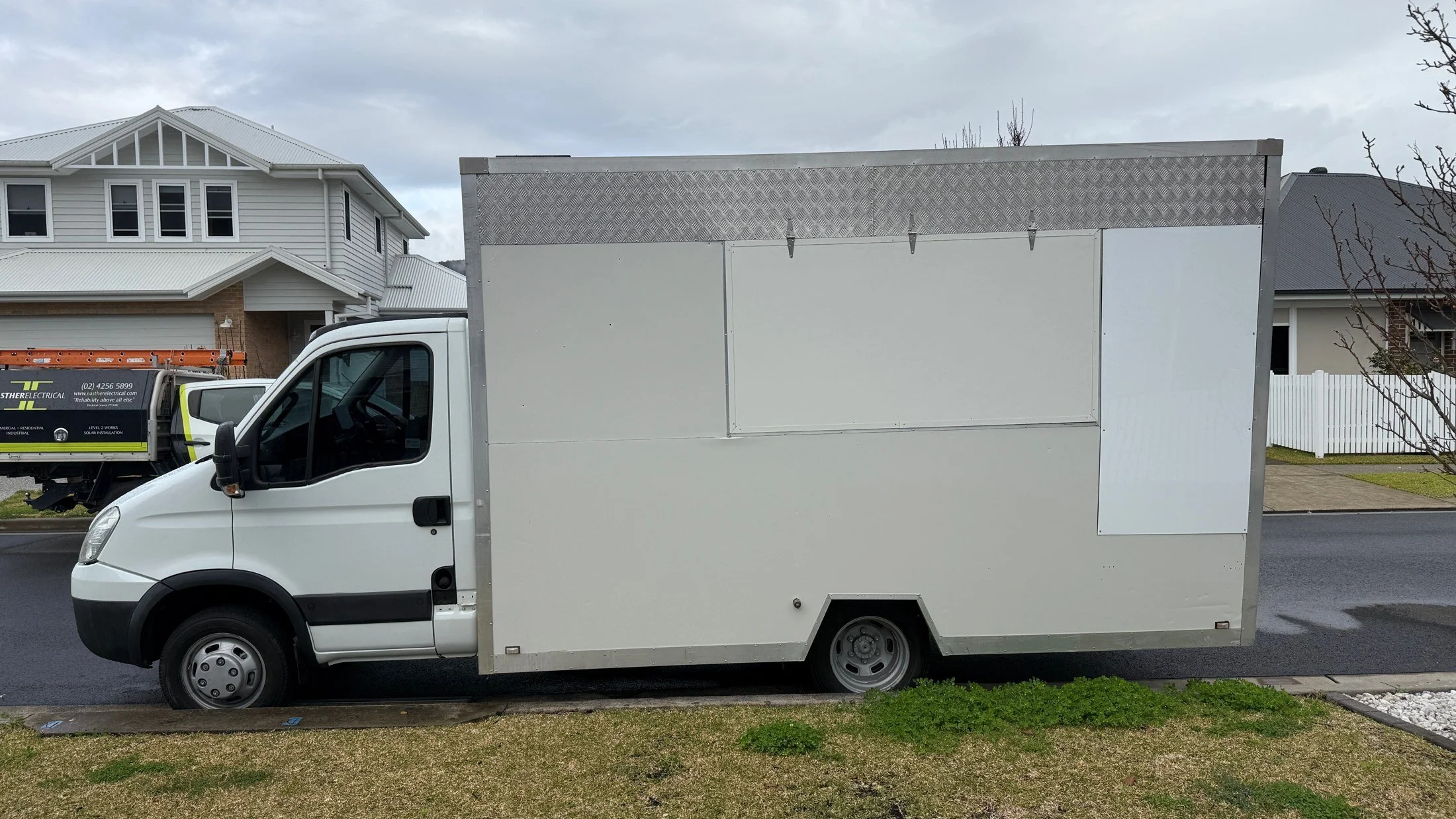 The truck with its plain white body and cab in August 2025