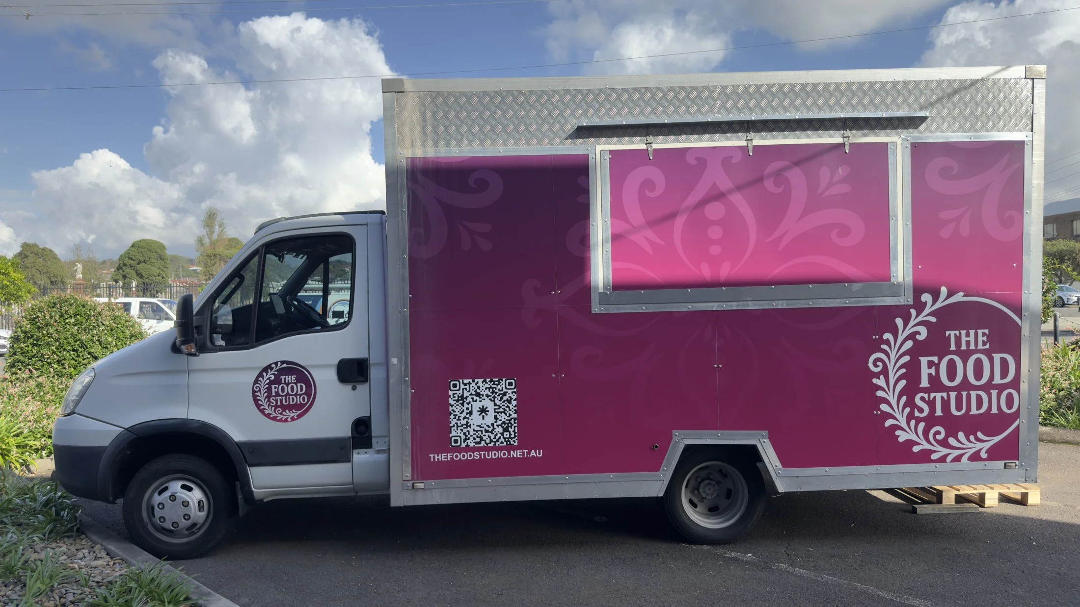 The completed pink Food Studio exterior with its logo and serving hatch