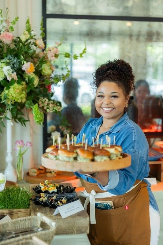 Lucy's server holding a tray of sliders at a catered reception