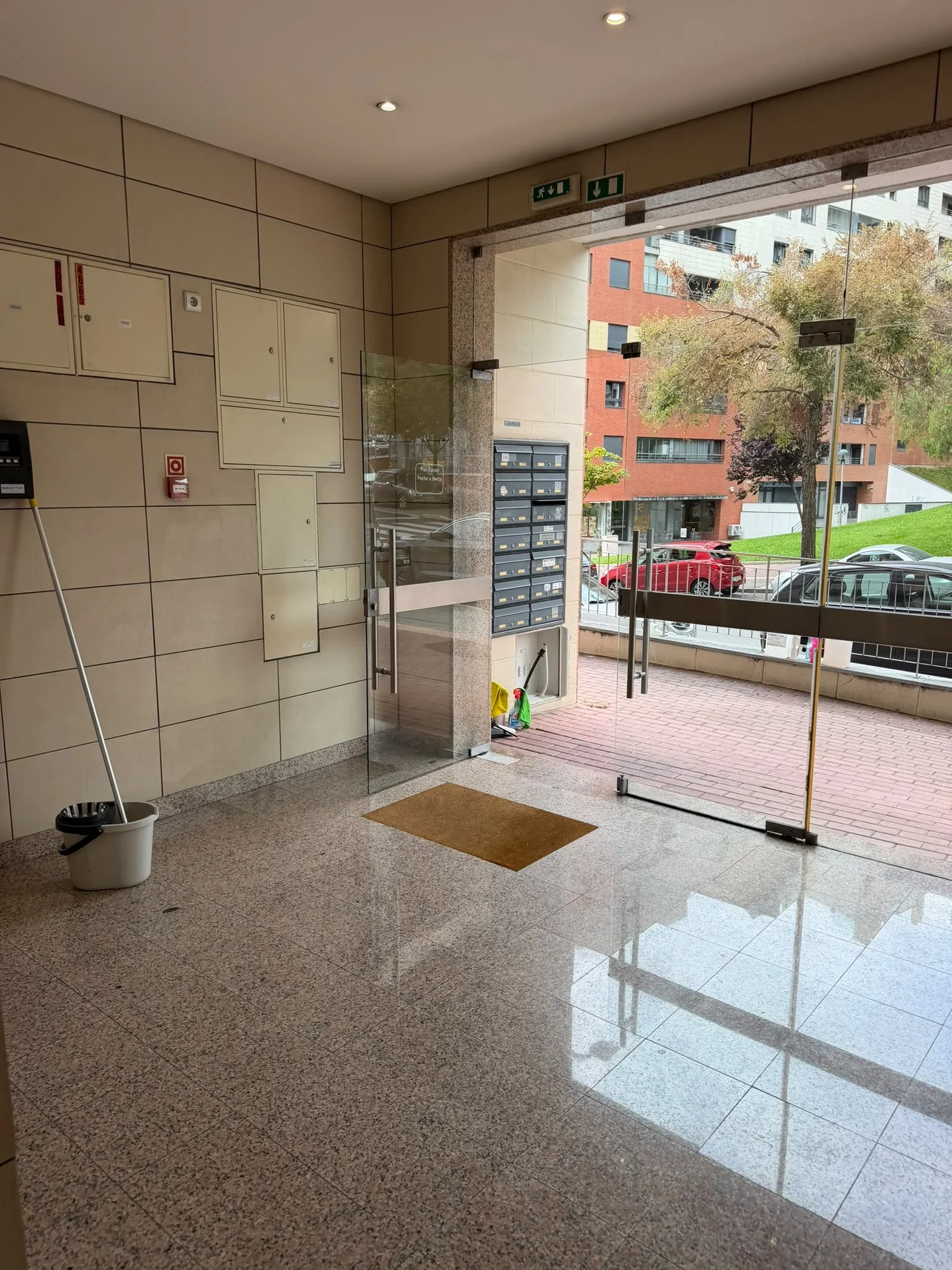 Hall de condomínio com piso limpo e portas de vidro