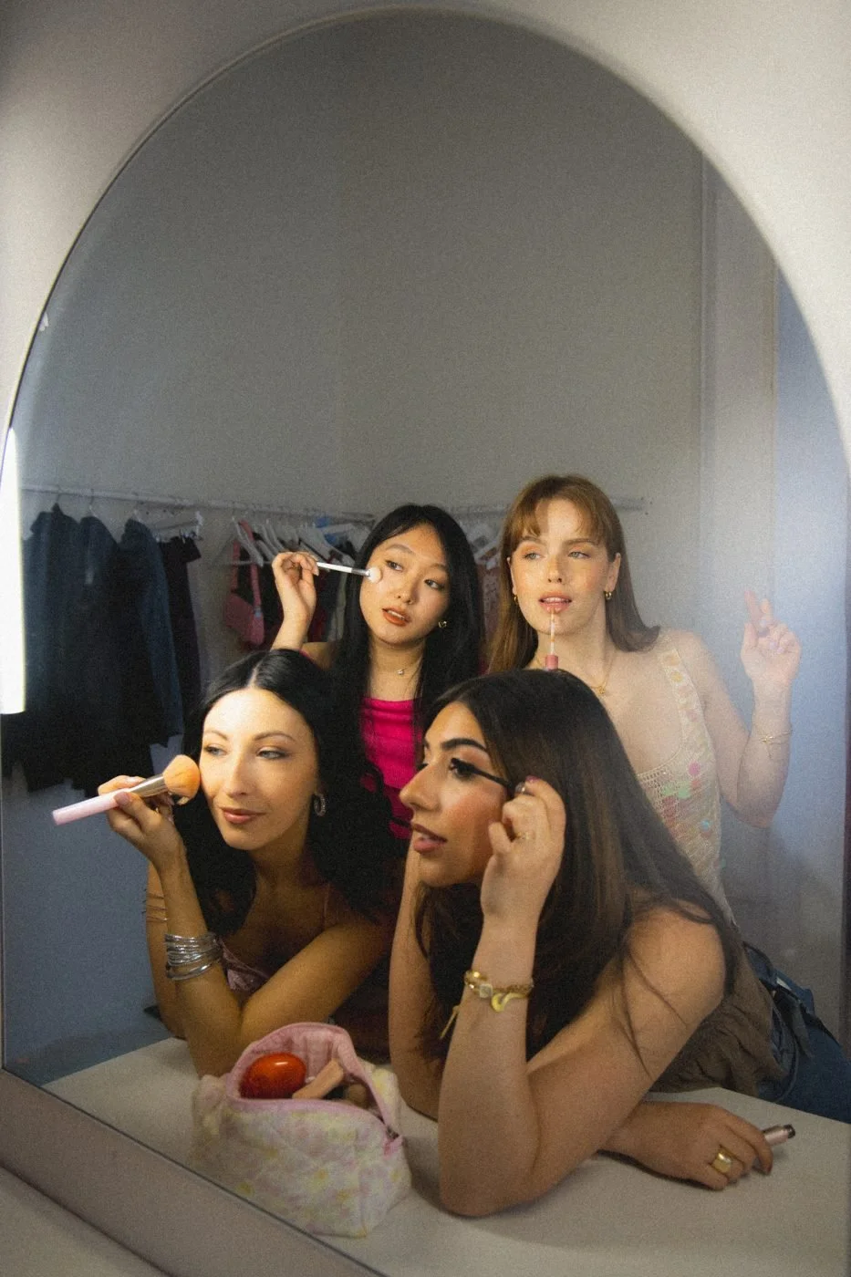 Friends doing makeup in a mirror