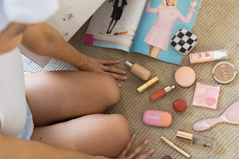 Indie beauty products on a rug next to a magazine