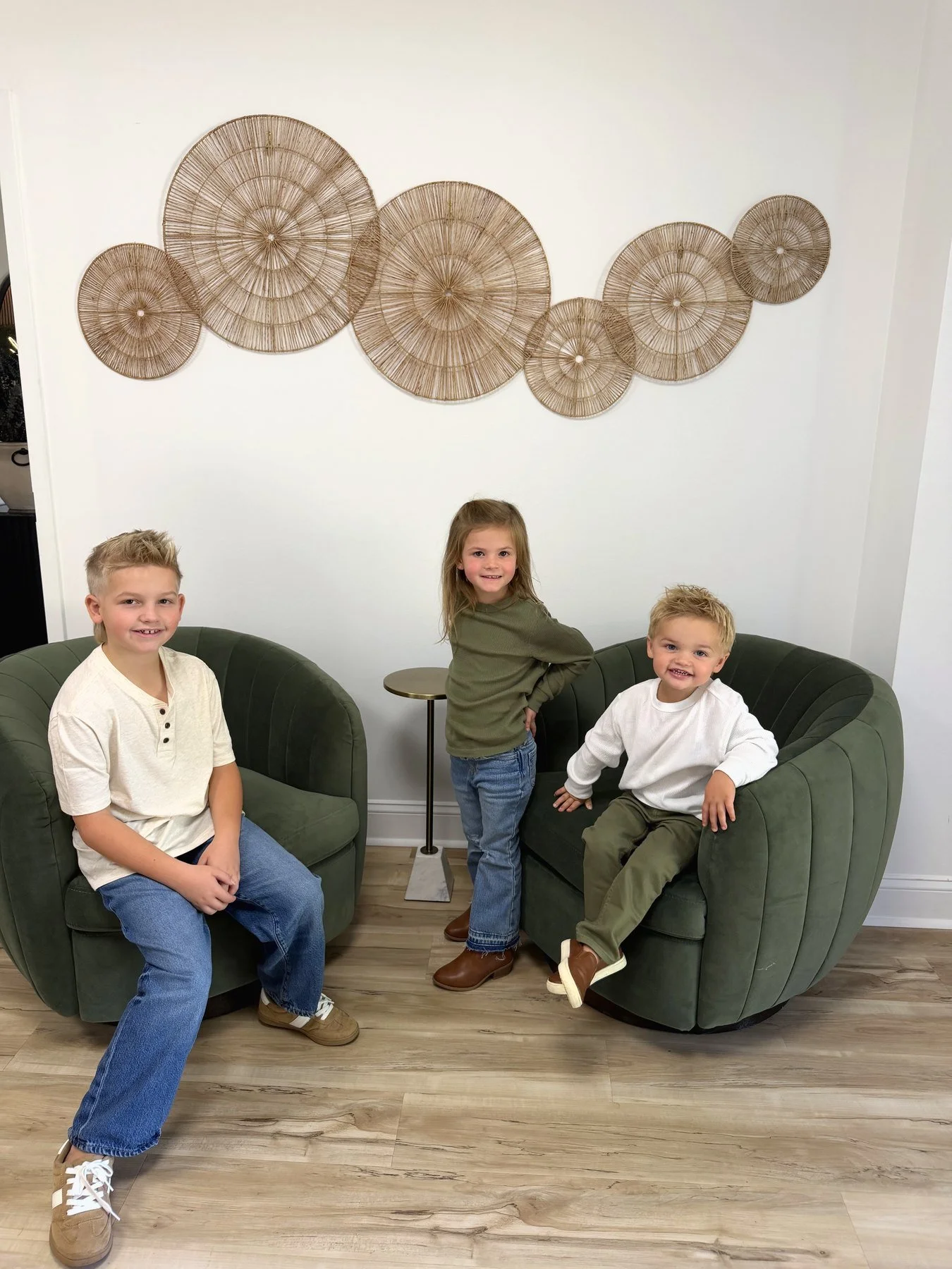 Three kids sitting together in the Raleigh Well lobby