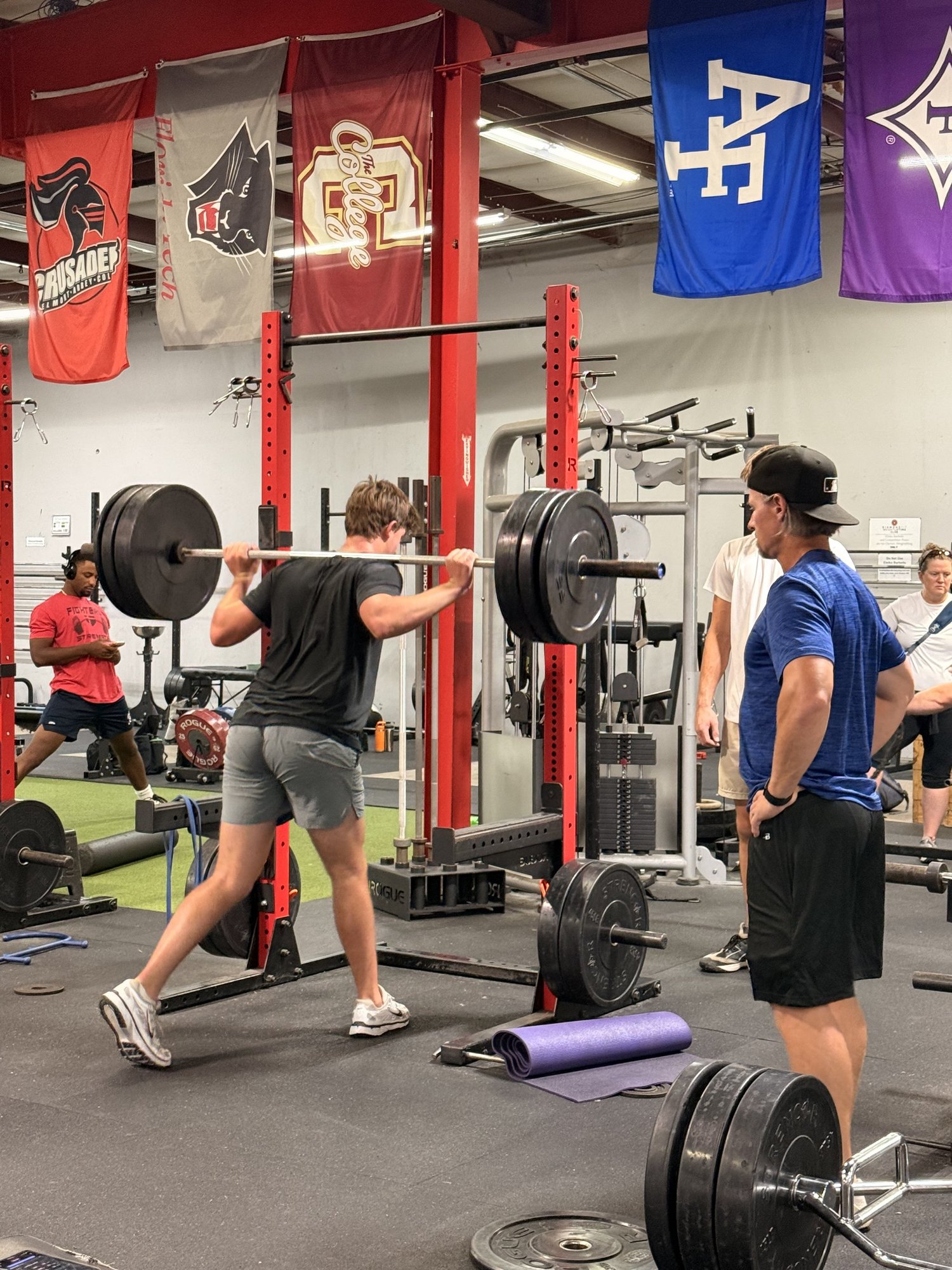 Young athlete squatting with a DiamondFit Performance coach