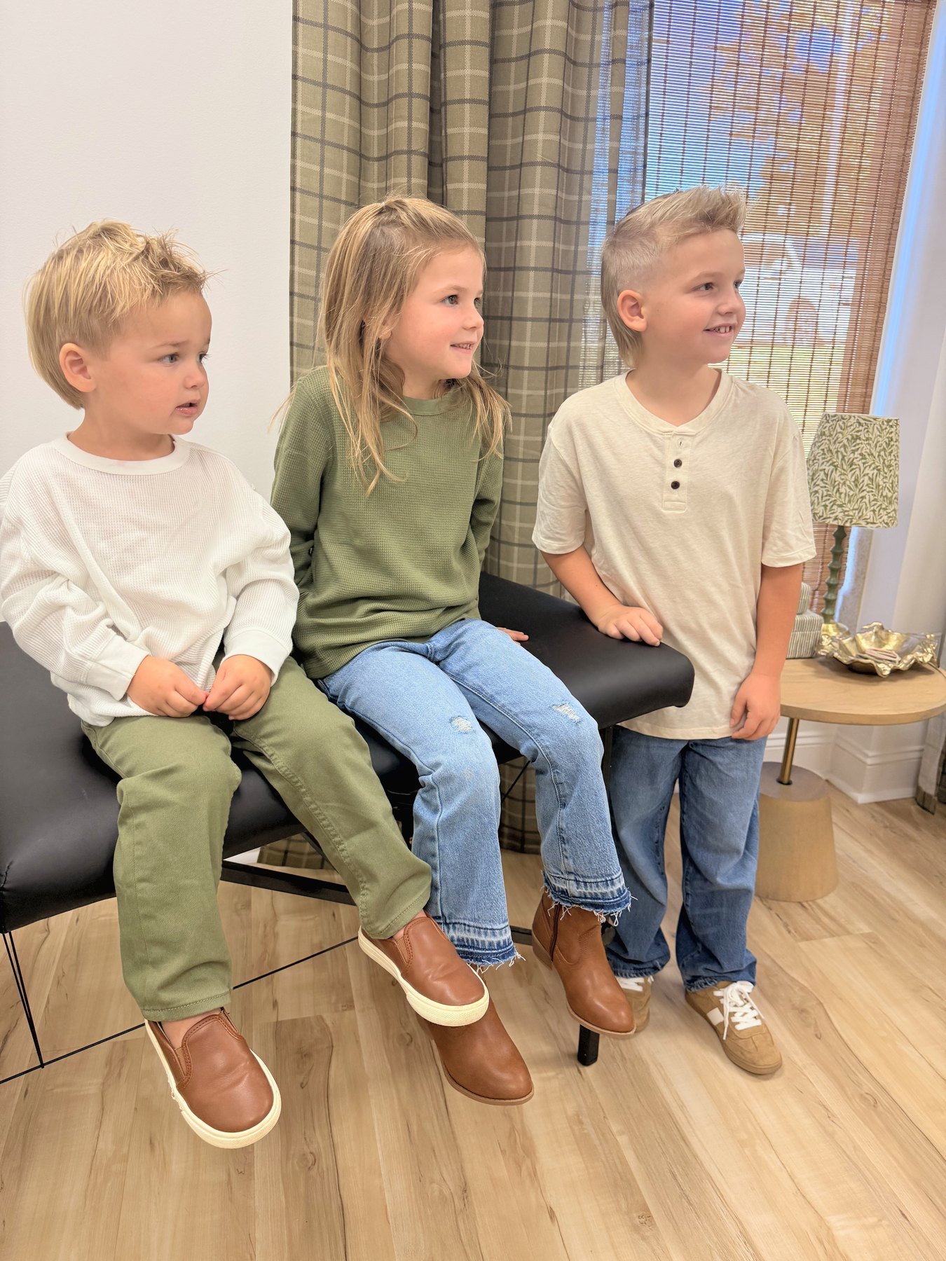 Three kids smiling during a family visit at Raleigh Well
