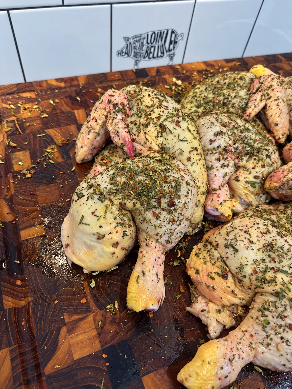 Raw herb-seasoned chickens ready to cook