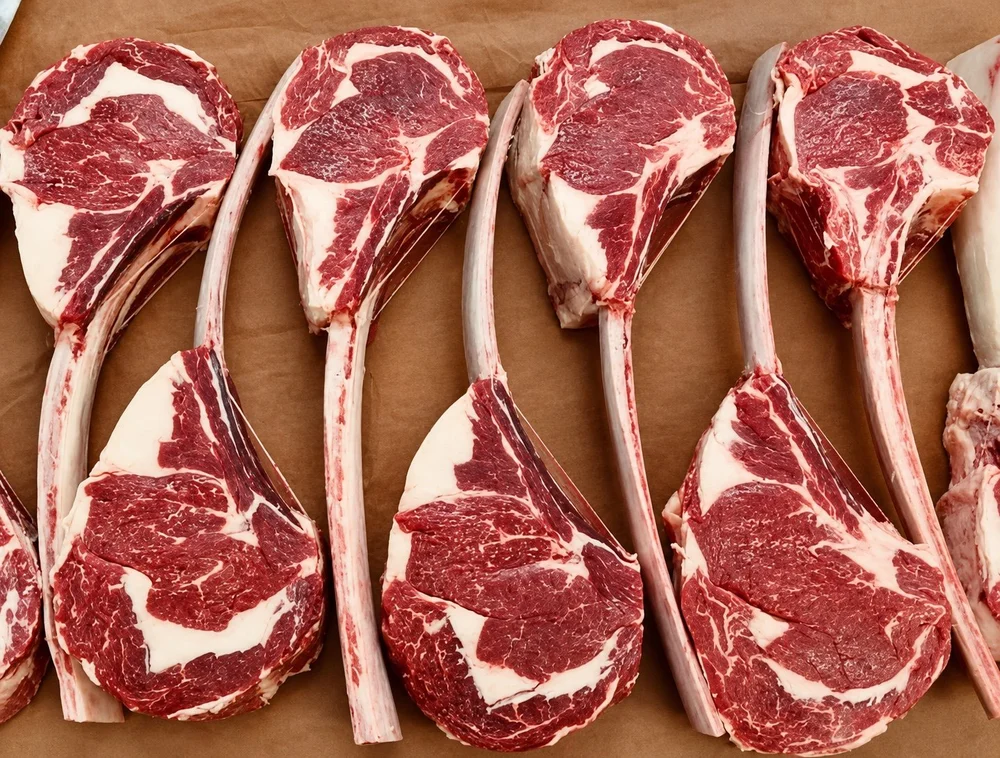 Marbled raw tomahawk steaks arranged on butcher's paper