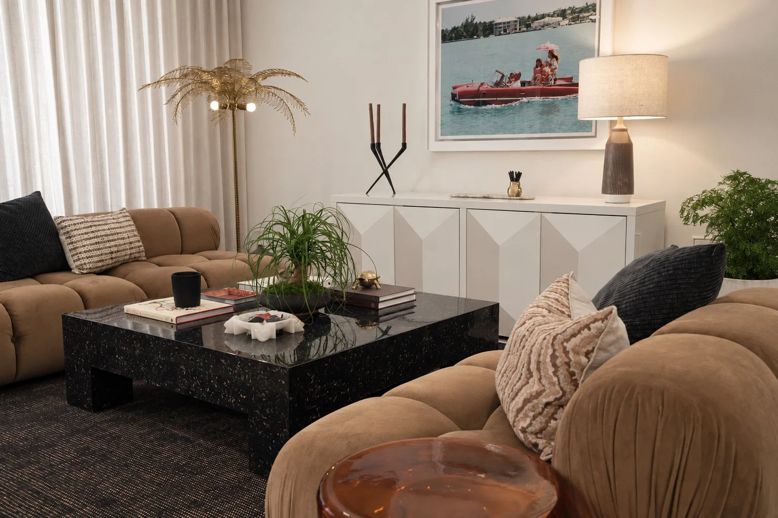 Warm neutral living room with sculptural seating, a black stone table and collected objects