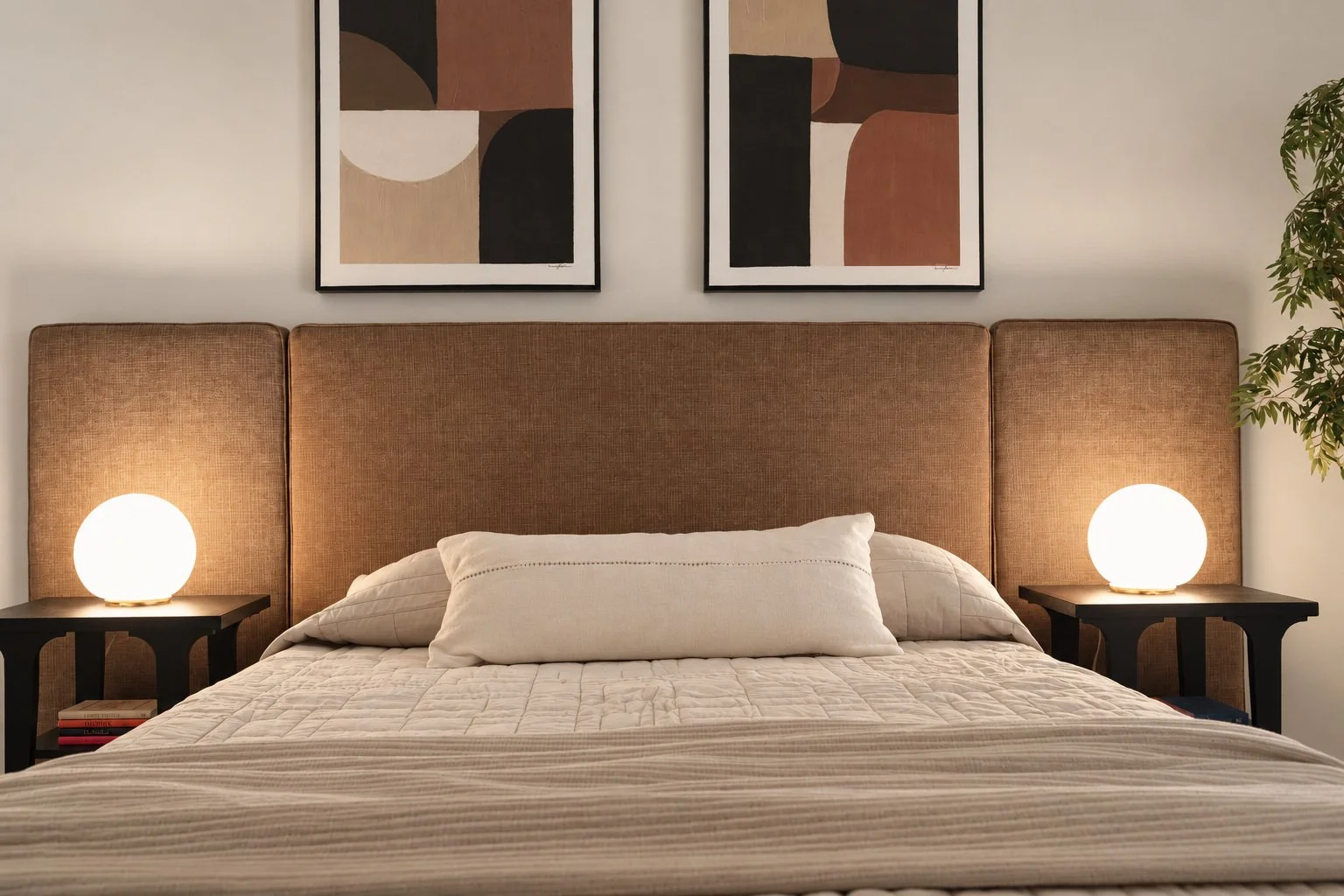 Bedroom with warm upholstered headboard, neutral bedding and paired globe lamps