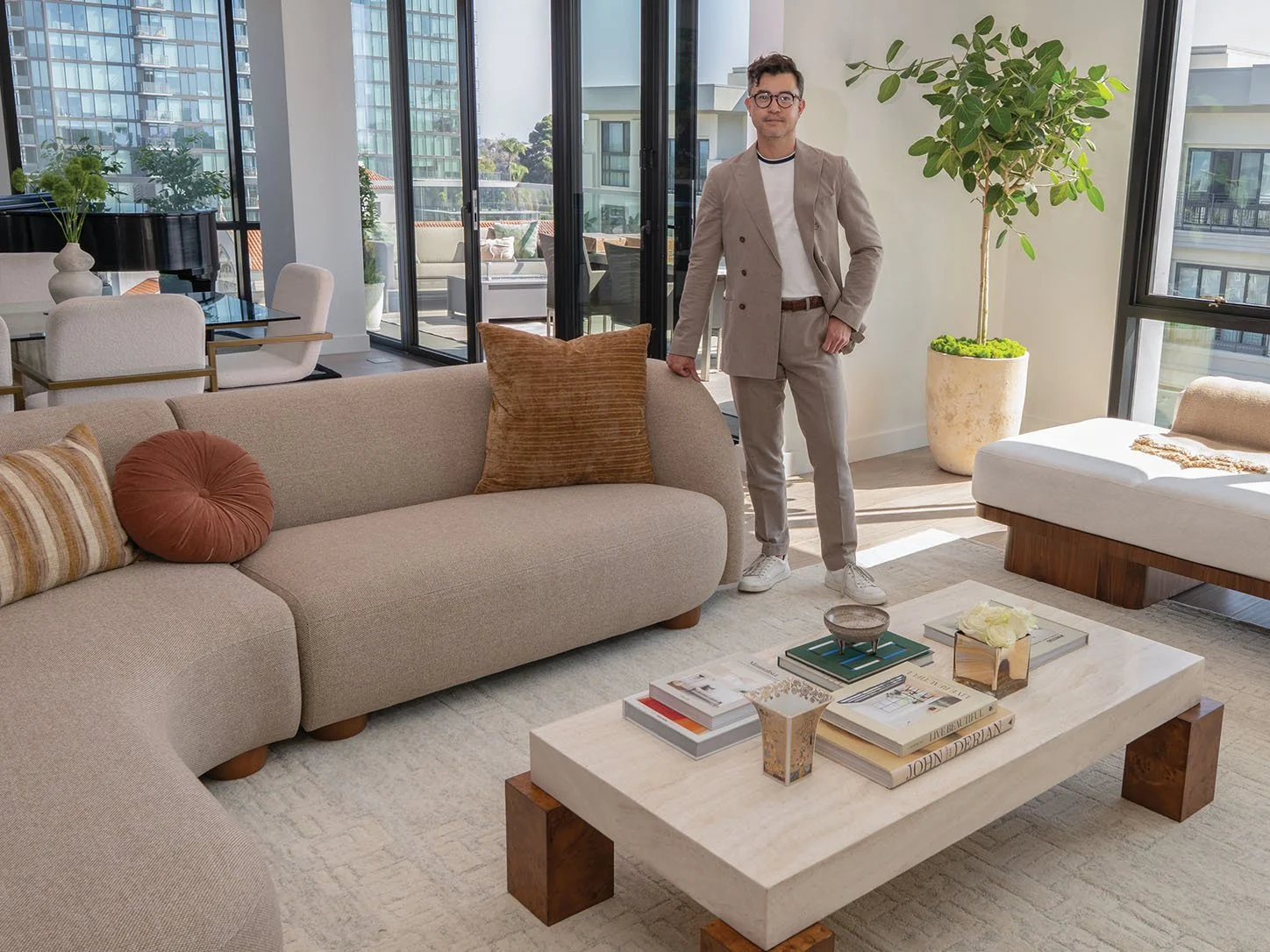 Daniel standing in a bright living room beside a neutral sofa