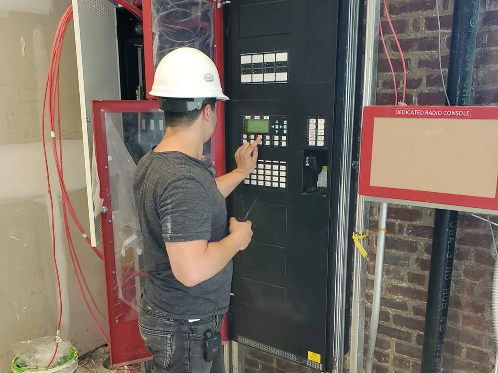 Technician programming a fire alarm control panel