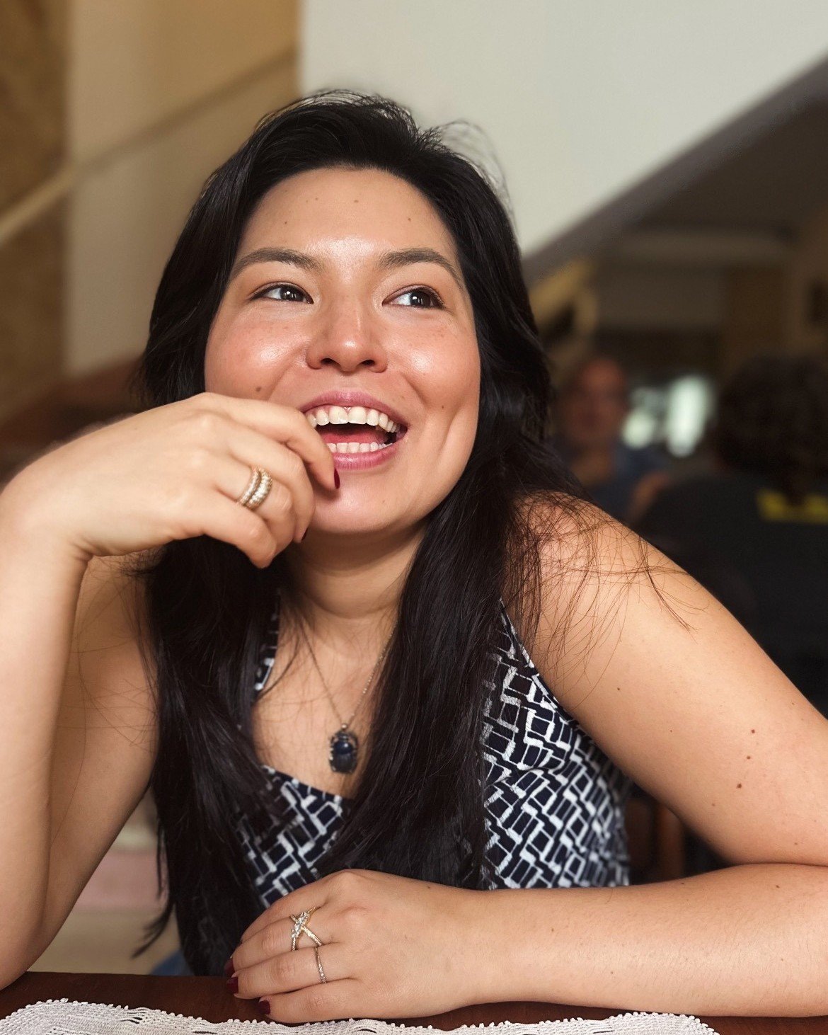 Dra. Aya Diniz rindo, numa conversa à mesa
