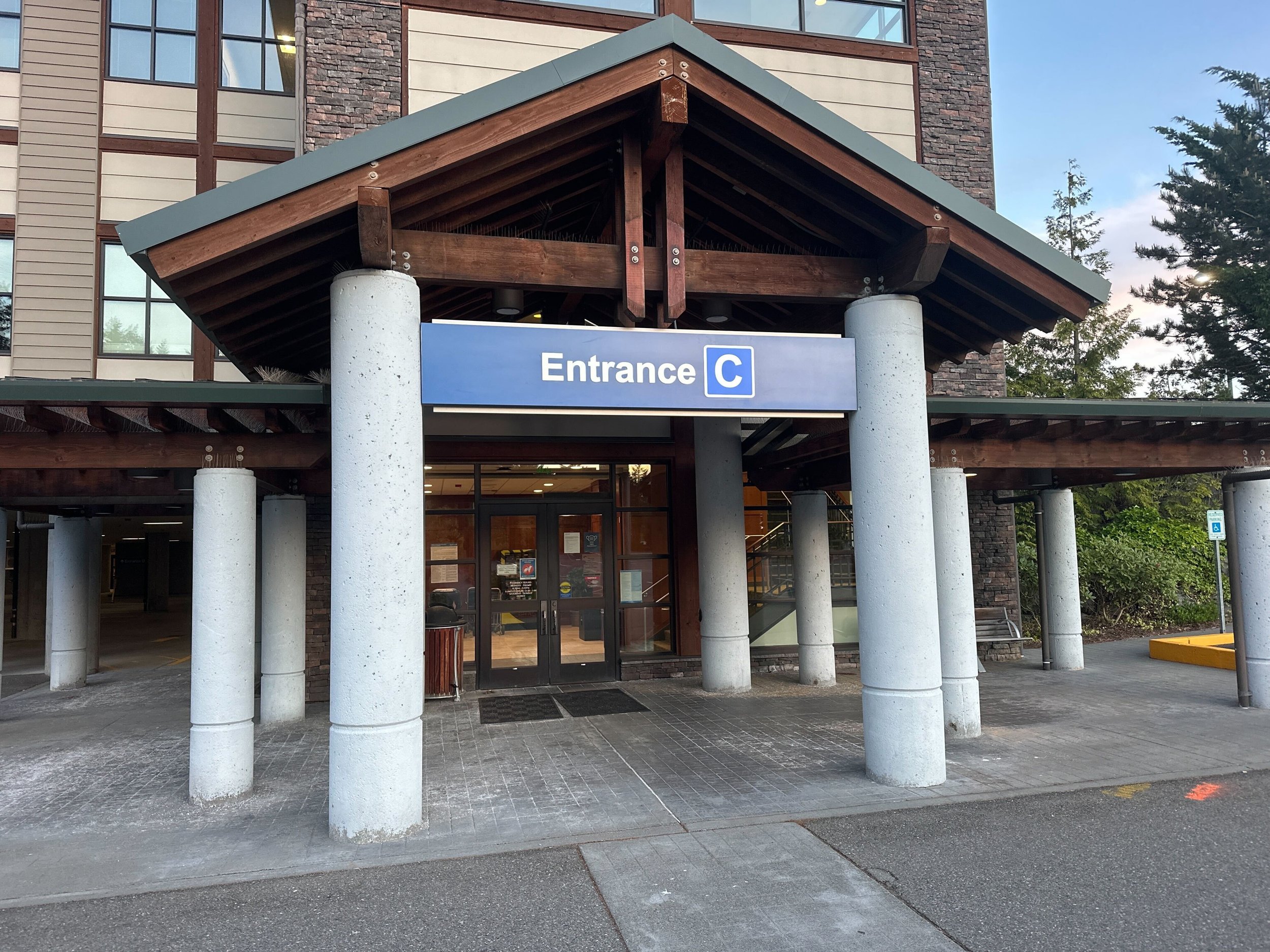 Existing MultiCare Entrance C illuminated cabinet under the timber-frame porte-cochère before demo by Plumb Signs, Gig Harbor WA