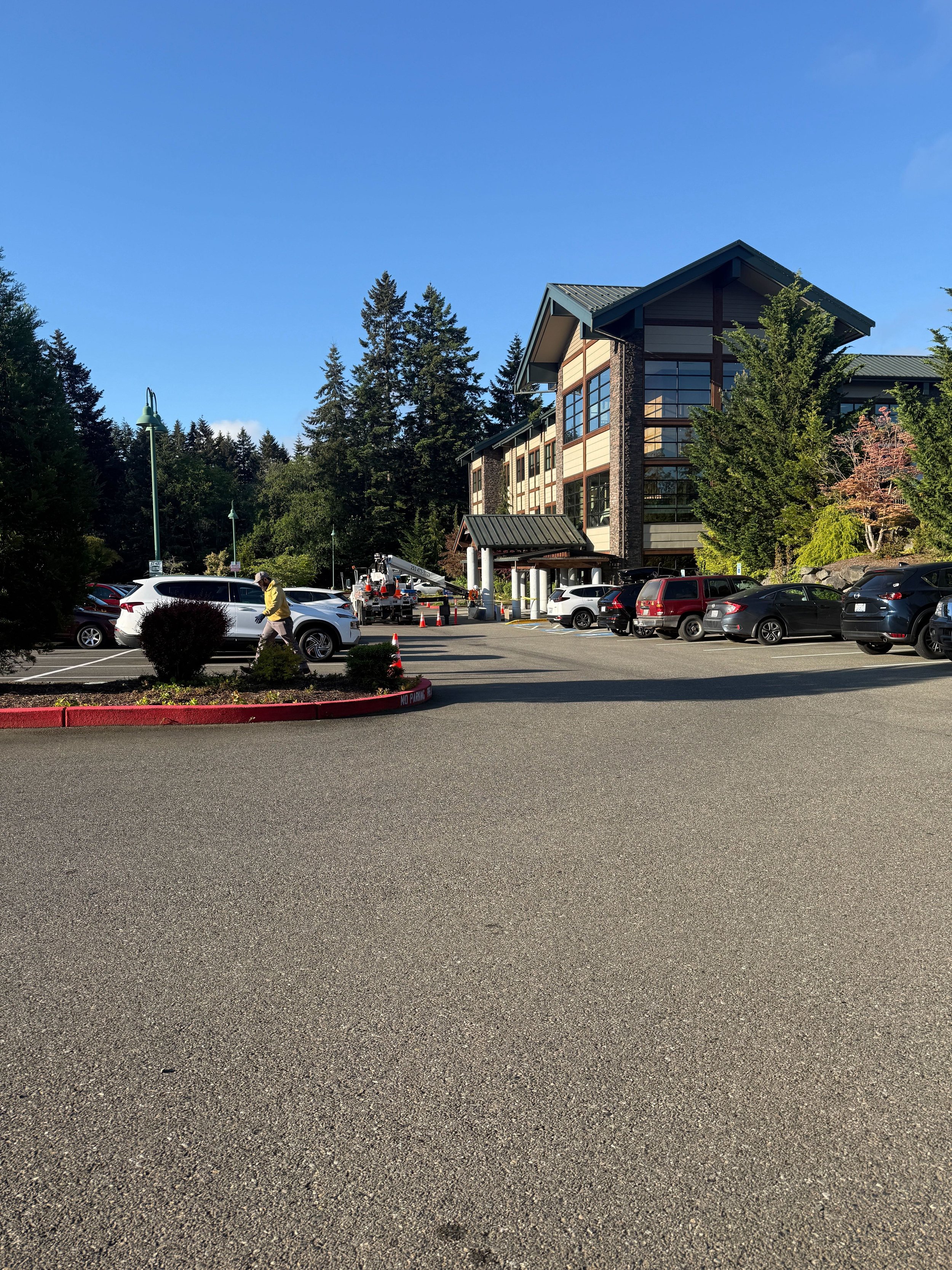 MultiCare Gig Harbor medical campus on install day with the Plumb Signs crane truck staged at the porte-cochère, Gig Harbor WA