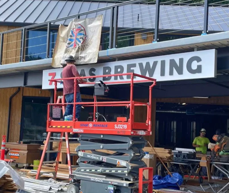 Installation in progress of bay-facing illuminated sign at Gig Harbor waterfront