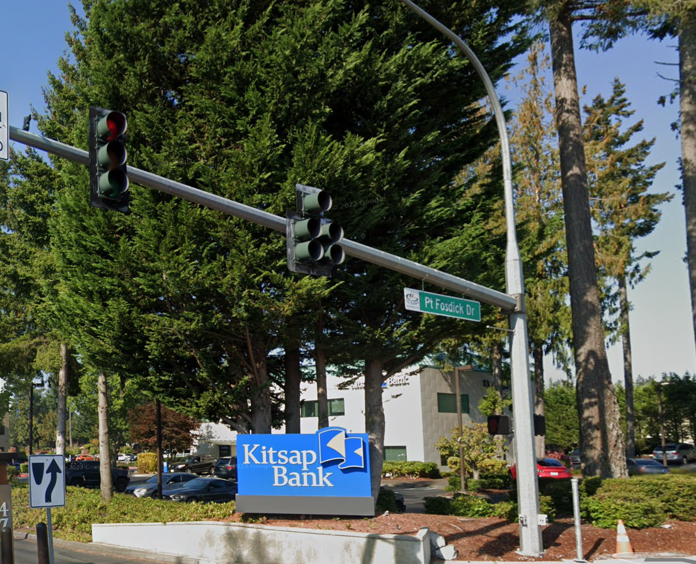 Additional view of the illuminated single-face Kitsap Bank street monument at the Gig Harbor branch on Point Fosdick Dr NW — translucent vinyl face overlay reading the Kitsap Bank brand in matched Pantone 2935C blue and Pantone 7408C gold, fabricated and installed by Plumb Signs of Tacoma