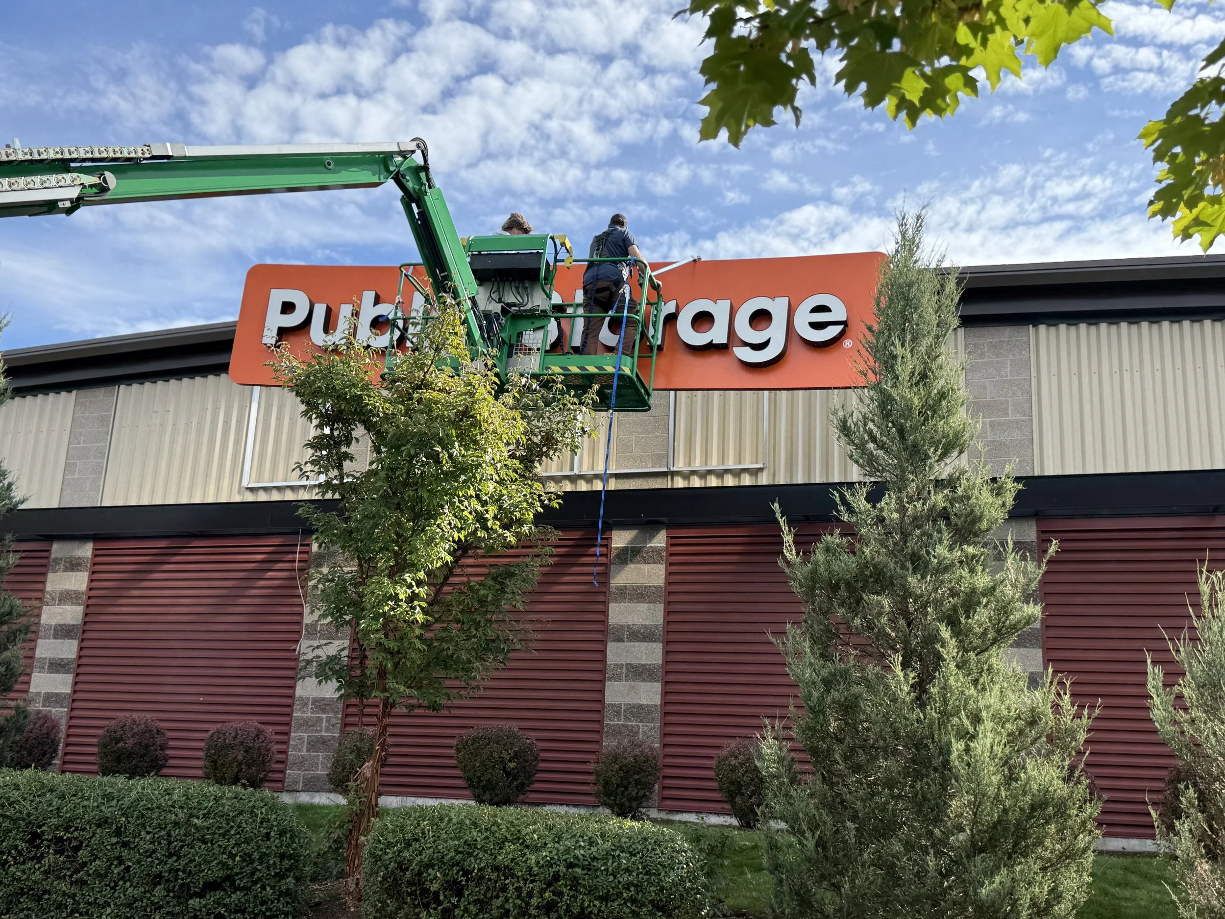 Technicians installing Public Storage channel letter signage