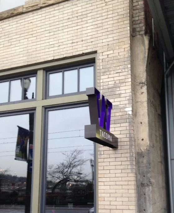 University of Washington Tacoma blade sign in daylight — campus wayfinding fabricated by Plumb Signs