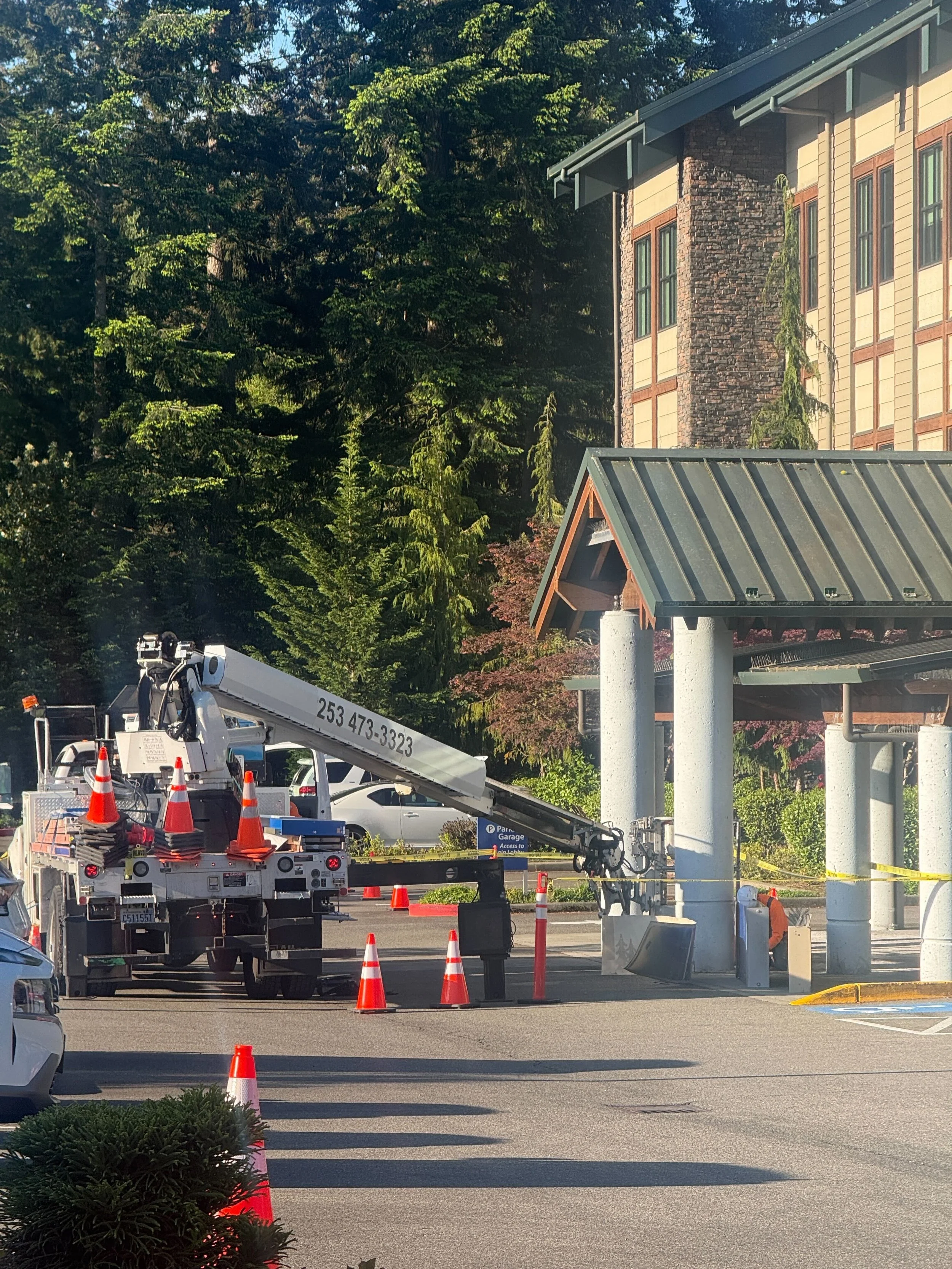 Plumb Signs crane truck with boom extended for illuminated canopy ID installation at the MultiCare Gig Harbor porte-cochère
