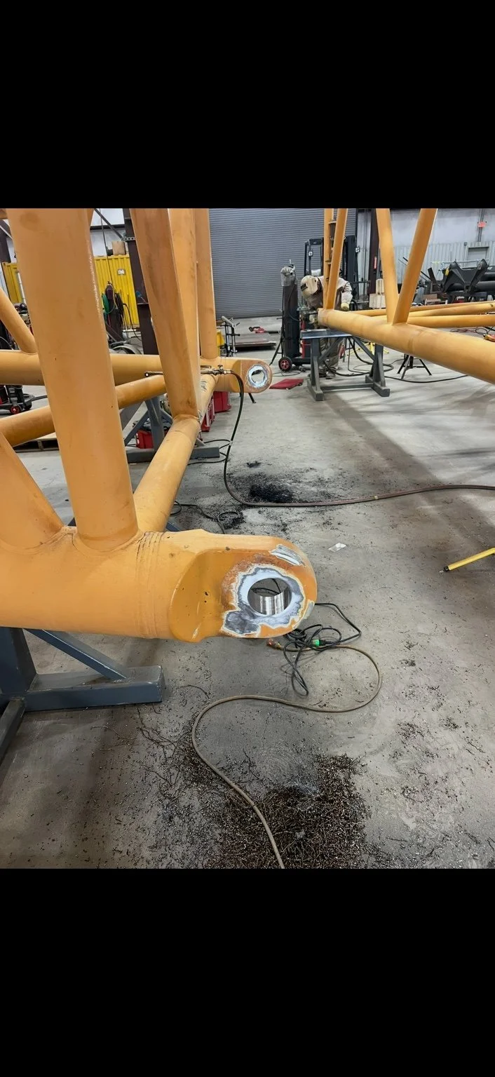 Yellow equipment frame with machined pivot points in the workshop
