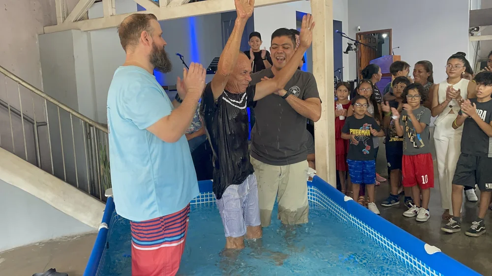 A man raising his arms after baptism